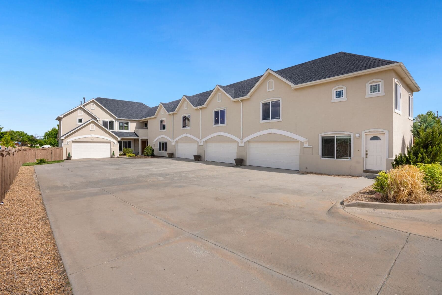 A modern suburban house with a wide asphalt driveway running up to the garage.