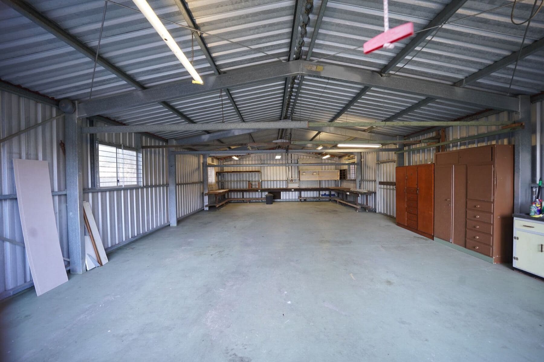 An empty building with a bare, unsealed concrete slab floor.