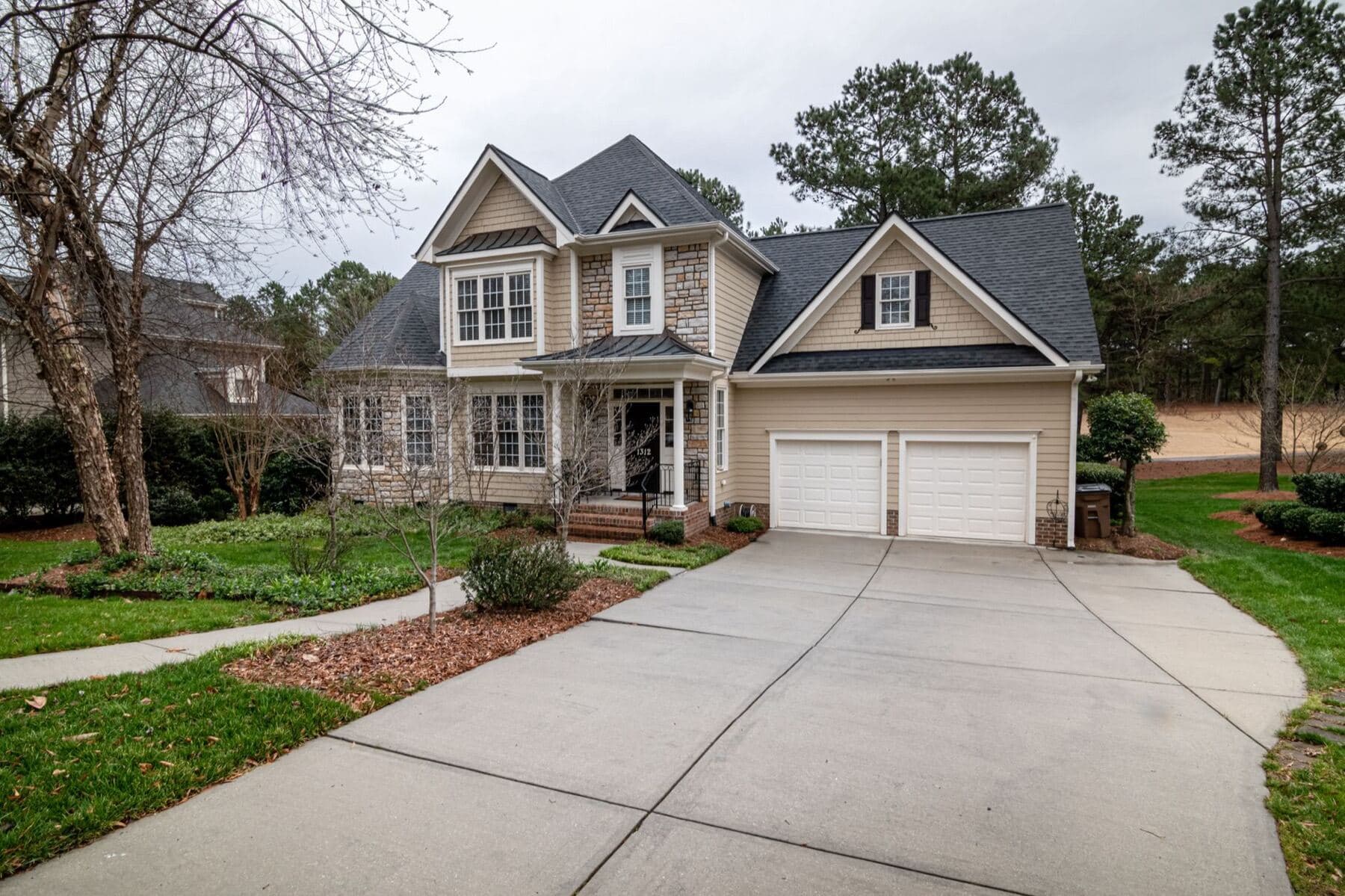 A suburban house with an attached double garage and a wide concrete driveway.